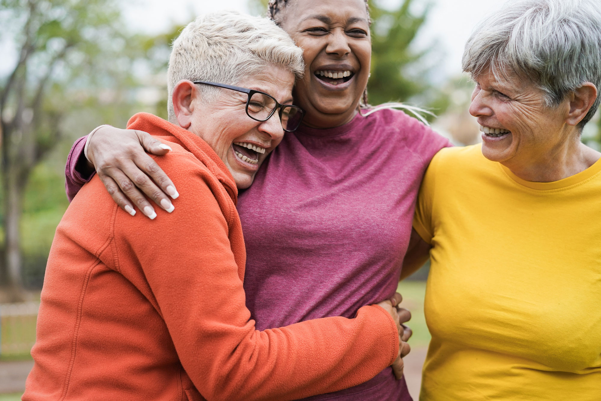 Multiracial senior women having fun together hugging each other