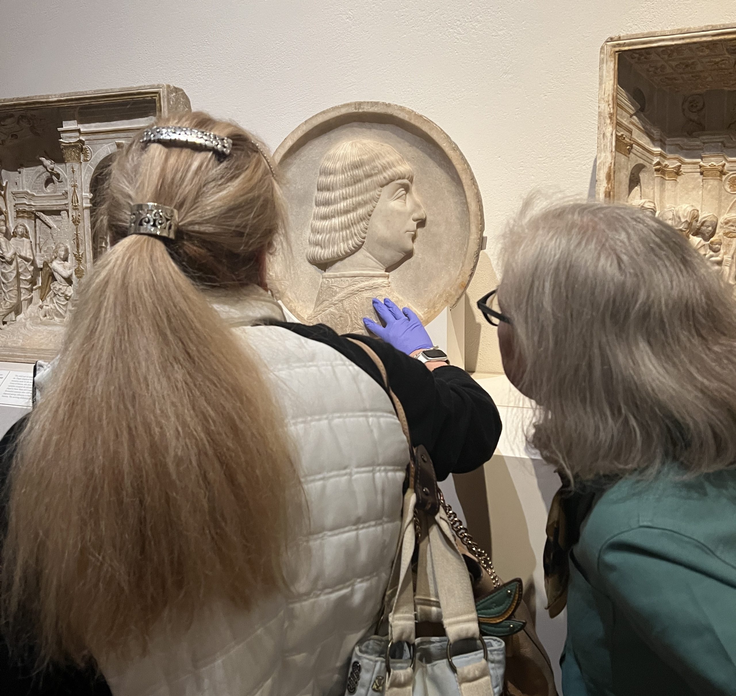 image of a woman touching a 3d piece of art at a museum